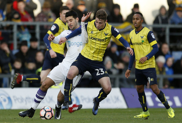 Ryan Ledson battles for the ball for his English club Oxford United