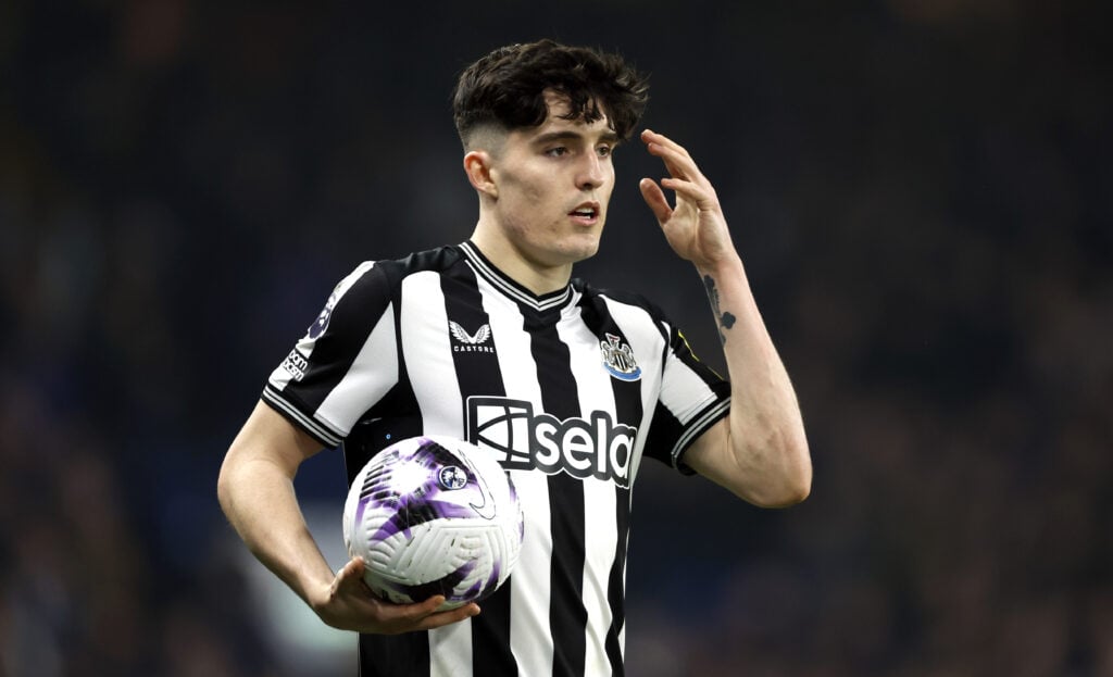 Tino Livramento for Newcastle holding the ball whilst pointing to his head