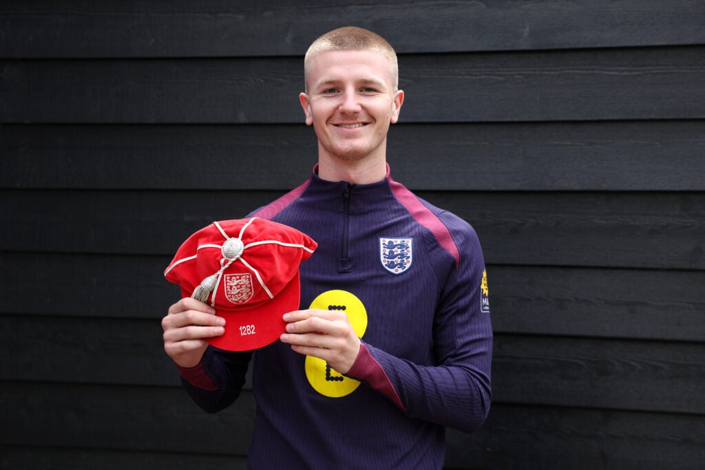 Adam Wharton poses in an England training jersey