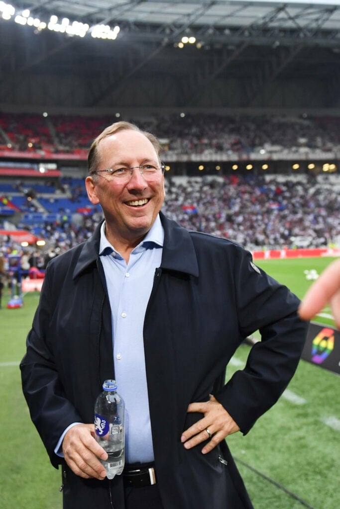 John Textor holding a bottle of water on the pitch at Wembley