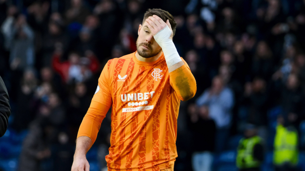 Jack Butland Rangers in an orange shirt holding his hand to his head in frustration