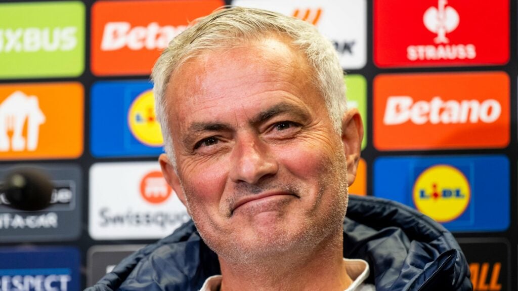 Jose Mourinho smiling in fenerbahce top in front of press conference board