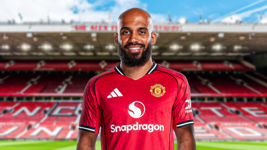 Bryan Mbeumo poses in a Manchester United shirt with a back drop of Old Trafford.