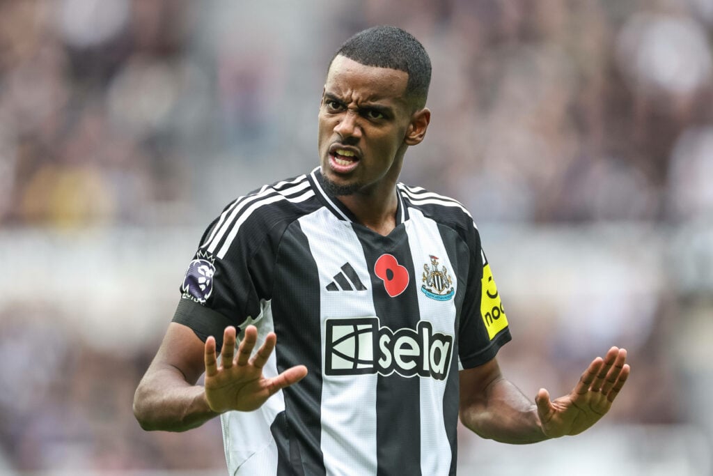 Alexander Isak telling supporters to calm down while in action for Newcastle United.