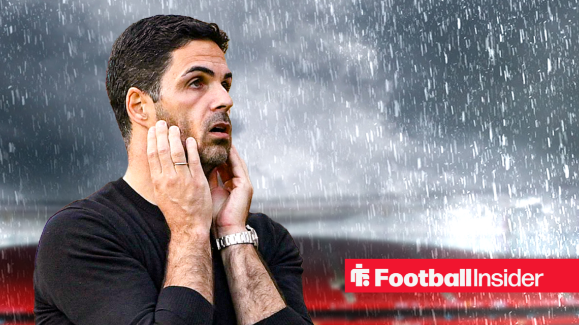 Arsenal manager Mikel Arteta with head in his hands against a raining Emirates Stadium,