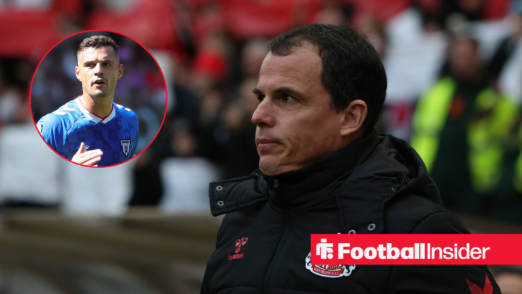 Regis Le Bris in a black coat and Granit Xhaka in a blue Sunderland kit in a red circle