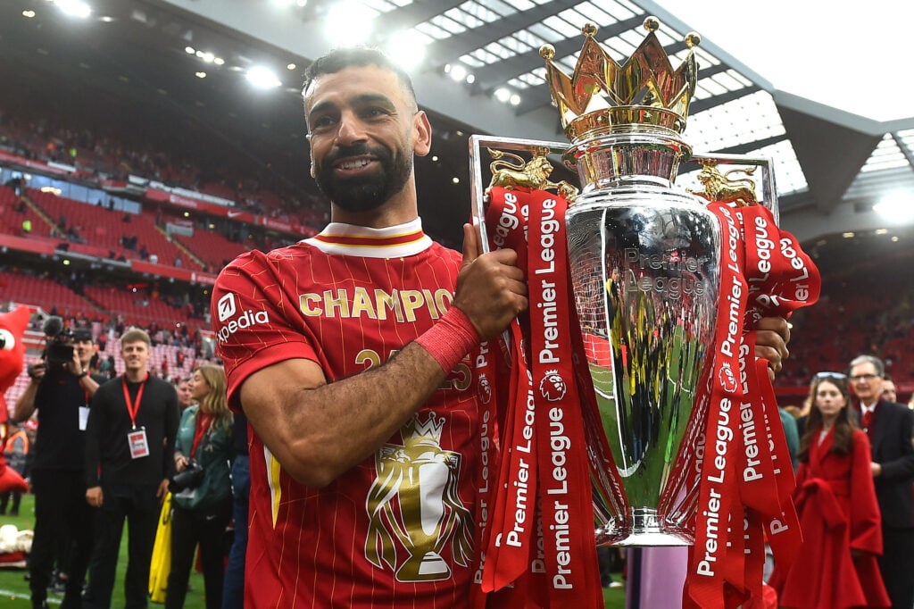 Mohamed Salah smiles as he lifts his second Premier League trophy with Liverpool at Anfield.