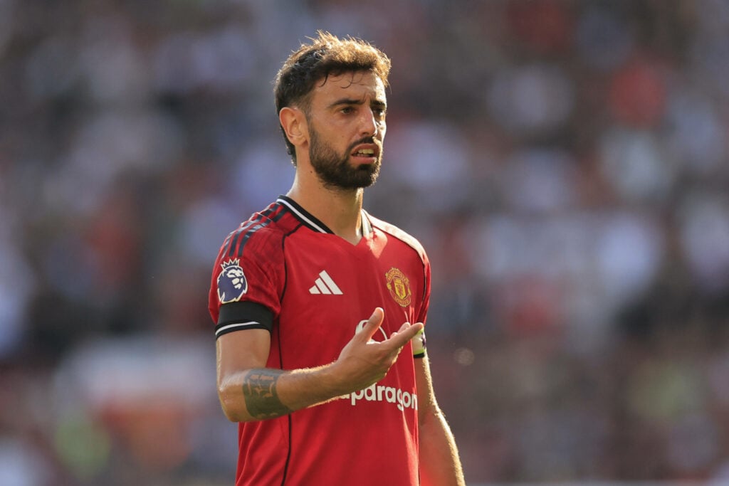Bruno Fernandes central with his right hand raised in front of his chest