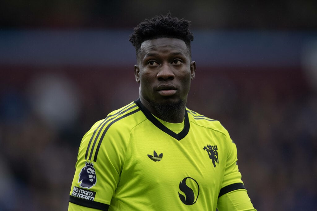 Manchester United goalkeeper Andre Onana looks concernedly towards the sky during a game.