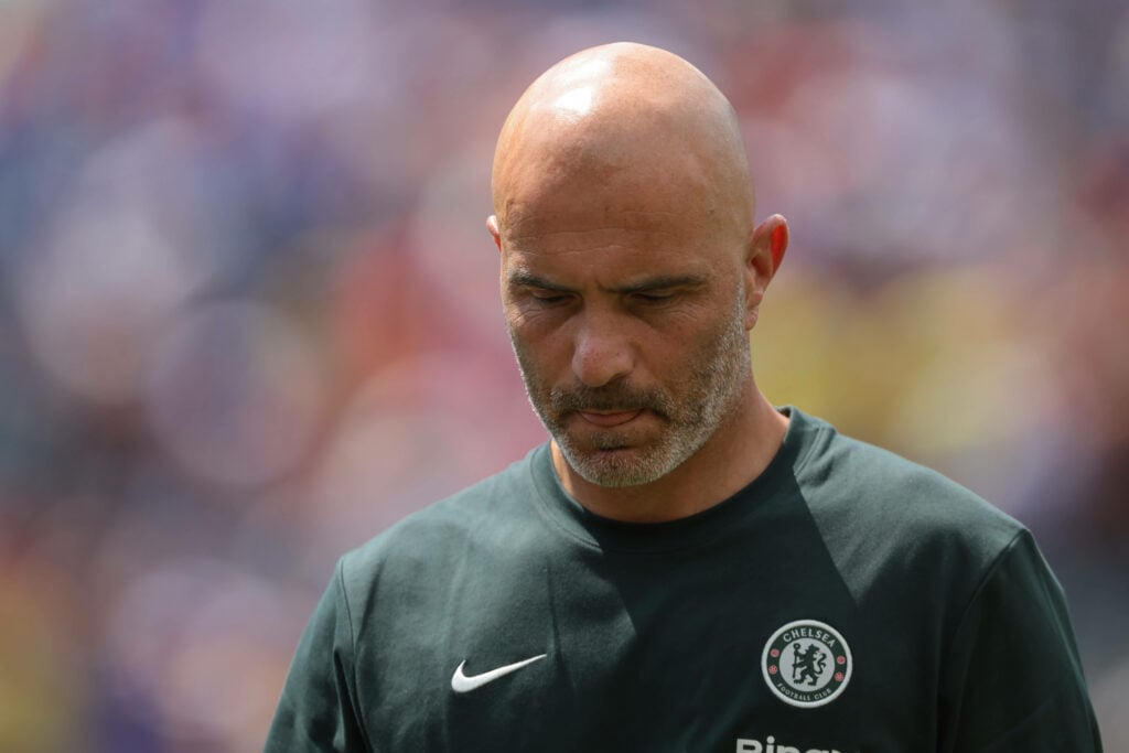 Chelsea manager Enzo Maresca stares at the floor while standing on the touchline.
