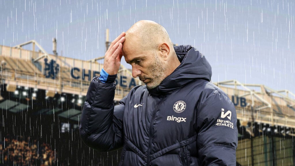 Chelsea manager Enzo Maresca holds his head as rain falls around him.