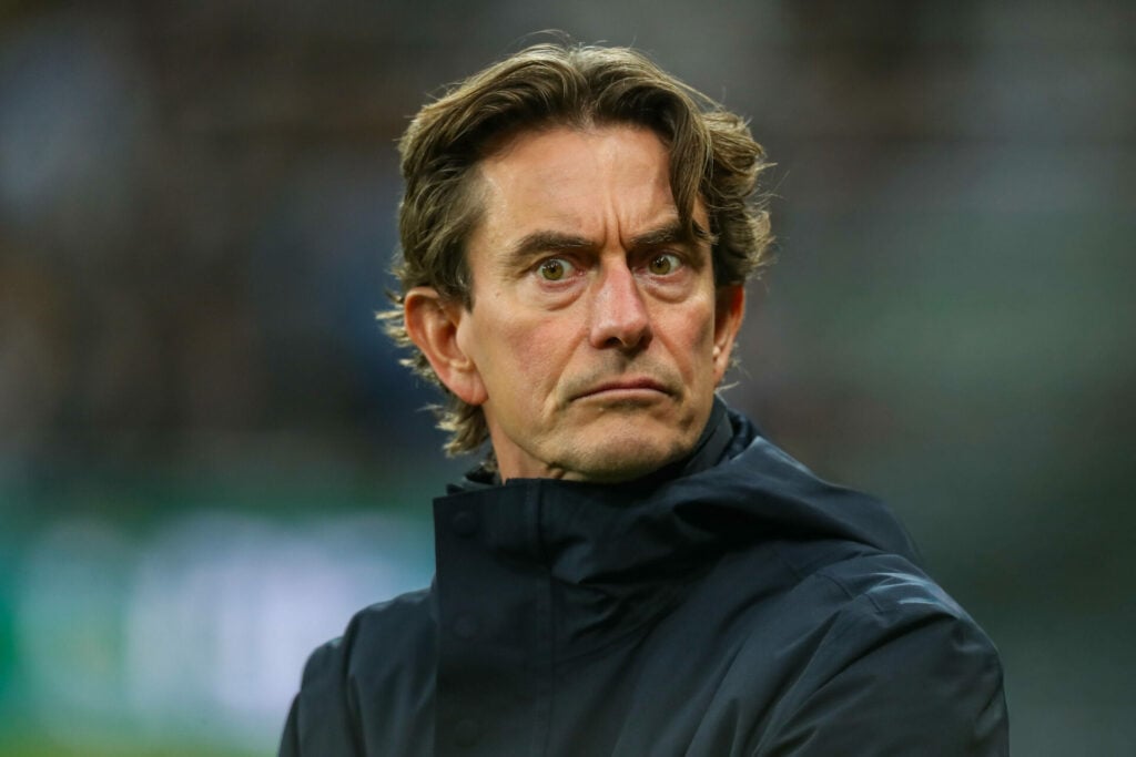 Tottenham manager Thomas Frank stands looking concerned on the touchline.