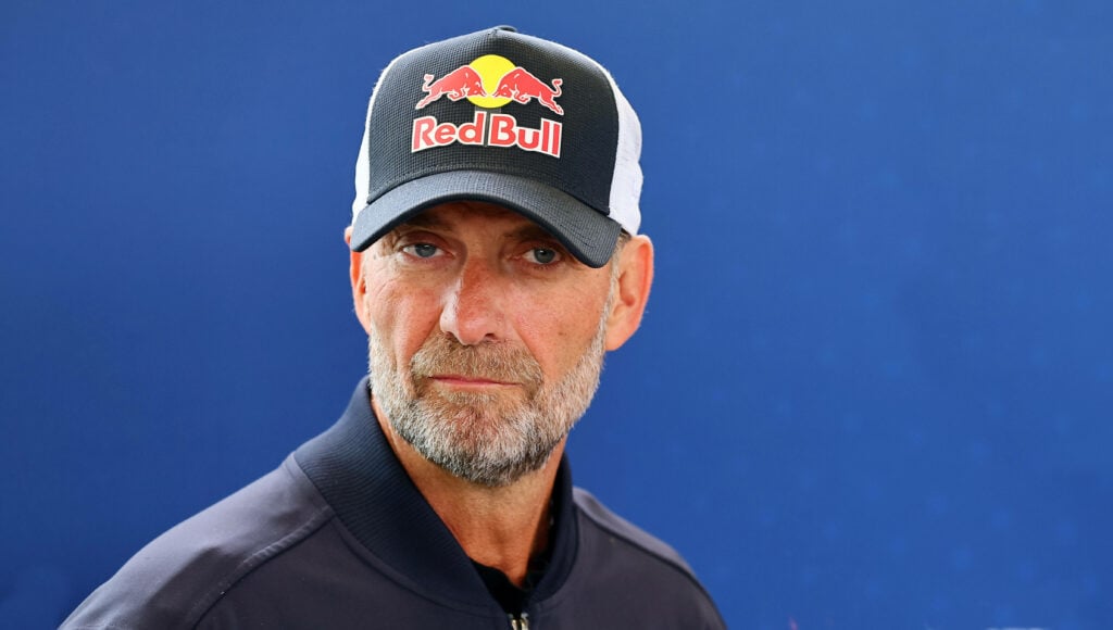 Ex-Liverpool manager Jurgen Klopp stands while wearing a Red Bull cap.