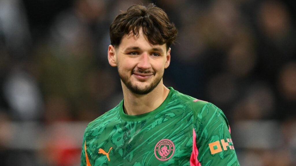 James Trafford smiling in a Man City shirt