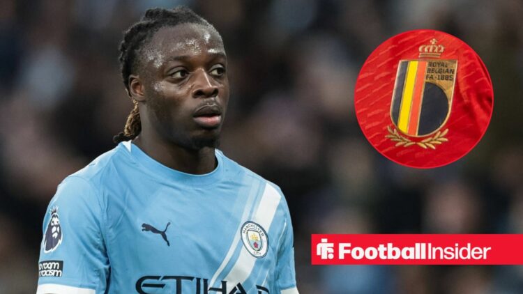 Manchester City winger Jeremy Doku stares towards the Belgium badge, which features in a circular inset.