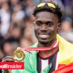 LASK defender Modou Keba Cisse holds up winners medal and smiles