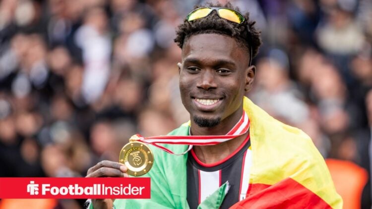 LASK defender Modou Keba Cisse holds up winners medal and smiles